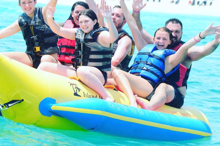 a group of people riding on the back of a boat in the water